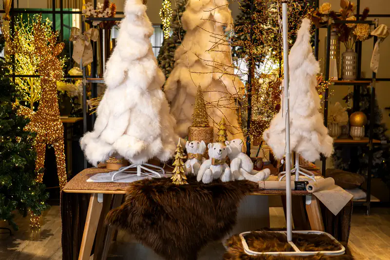 Alberi di pelliccia bianca, orsetti e luci dorate in un allestimento avorio e oro dello showroom