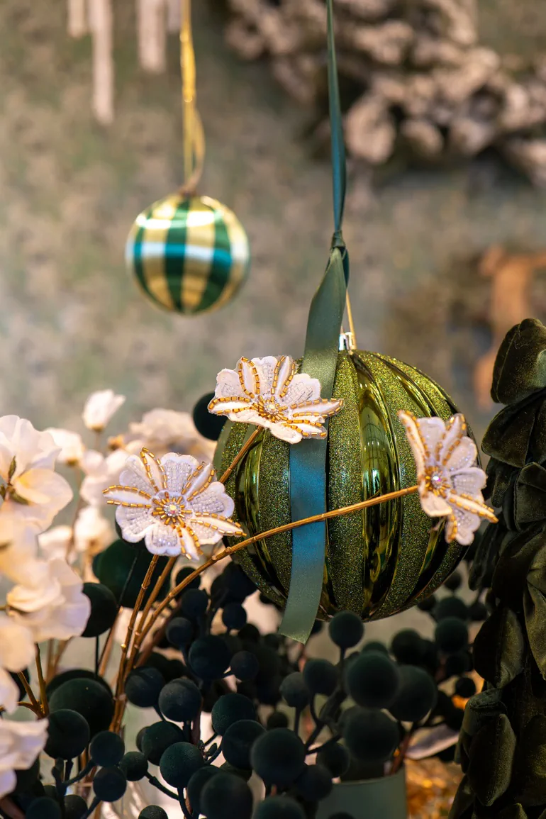Sfera verde con nastro, fiori bianchi bordati d'oro e bacche verde scuro